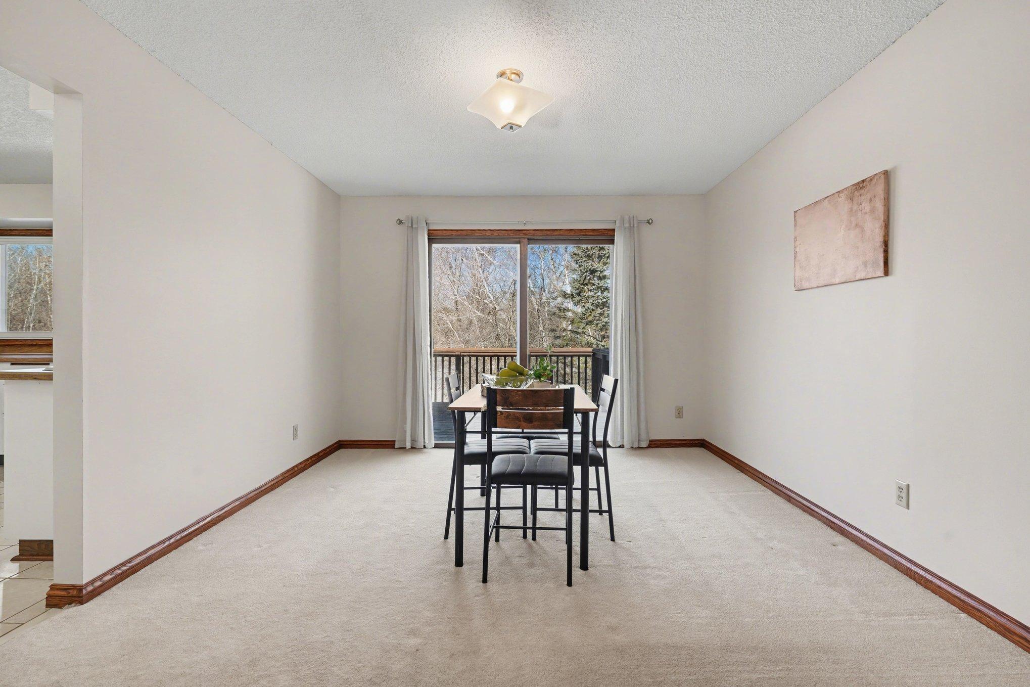 Ideal for hosting! This large formal dining area fits a full-sized set and flows seamlessly into the living room. Features the first of two sliding doors leading to the expansive back deck for easy indoor-outdoor living.