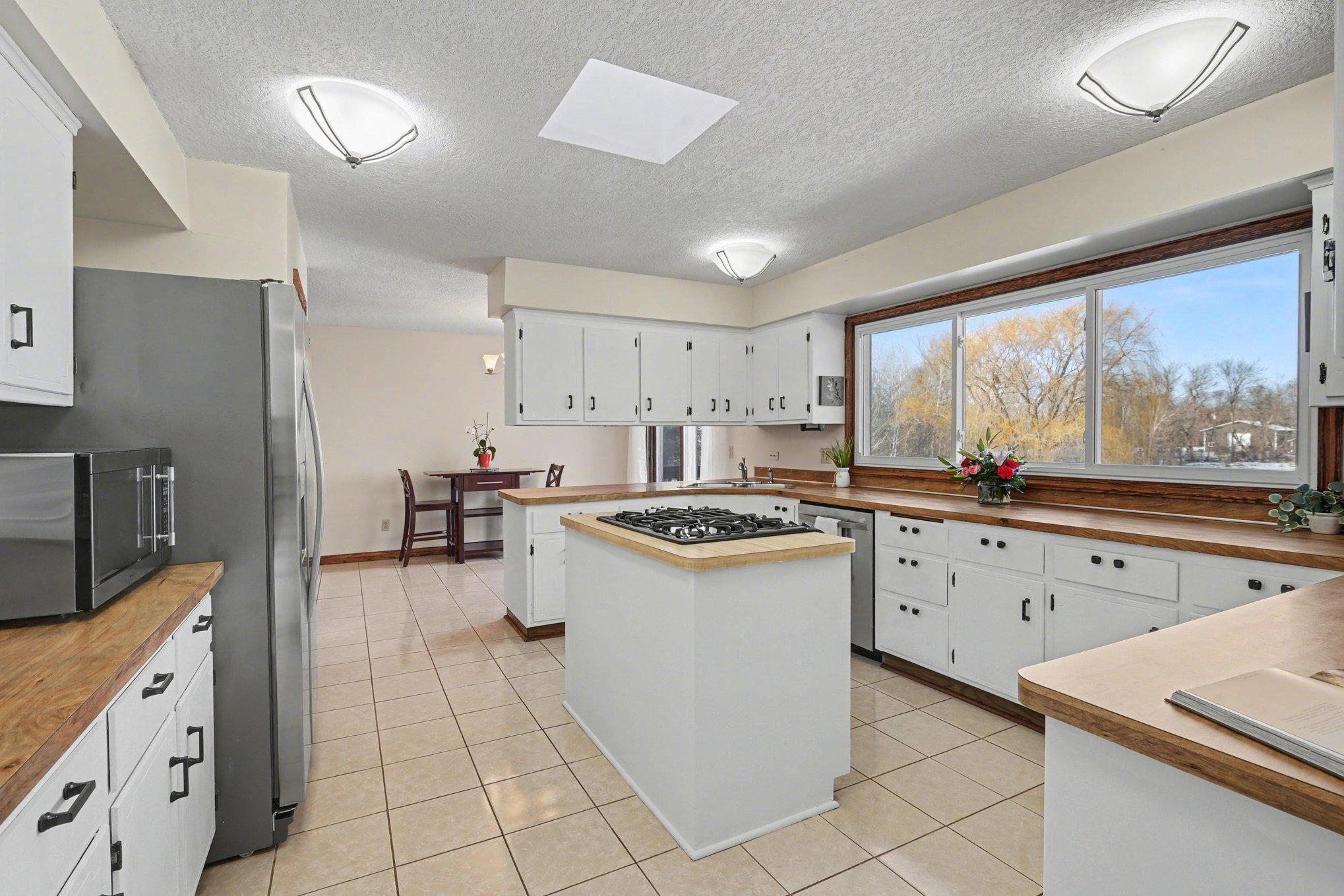 Large, bright, and functional! The kitchen features abundant cabinet and counter space. Three large windows offer stunning views of the gorgeous backyard and pond. An absolute must-see!