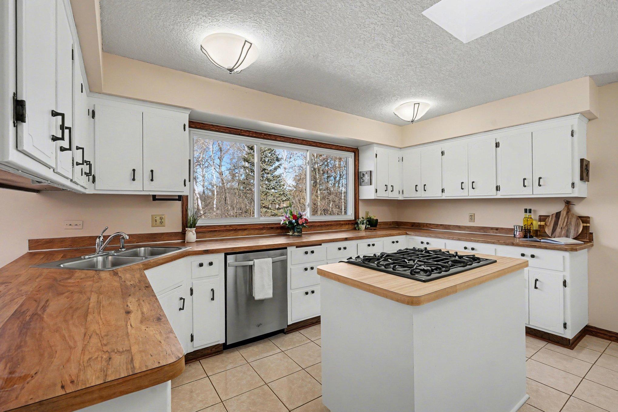 Meal prep is a joy with gorgeous views of the wooded yard and pond through three large windows! This spacious layout easily accommodates multiple chefs, making it the perfect hub for family and friends.