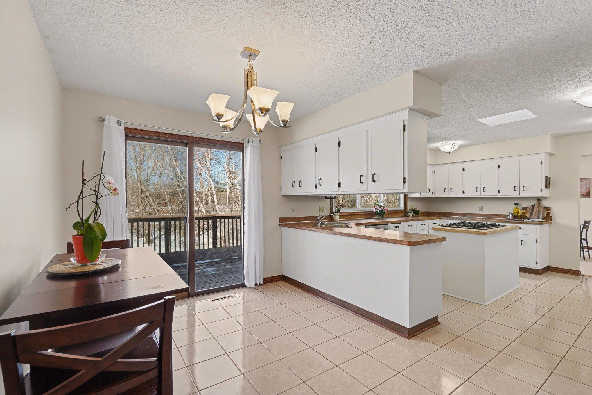 The informal dining room is perfectly situated for easy meals. Enjoy the view and step right out onto the expansive deck through the sliding glass doors. Ideal for BBQs!