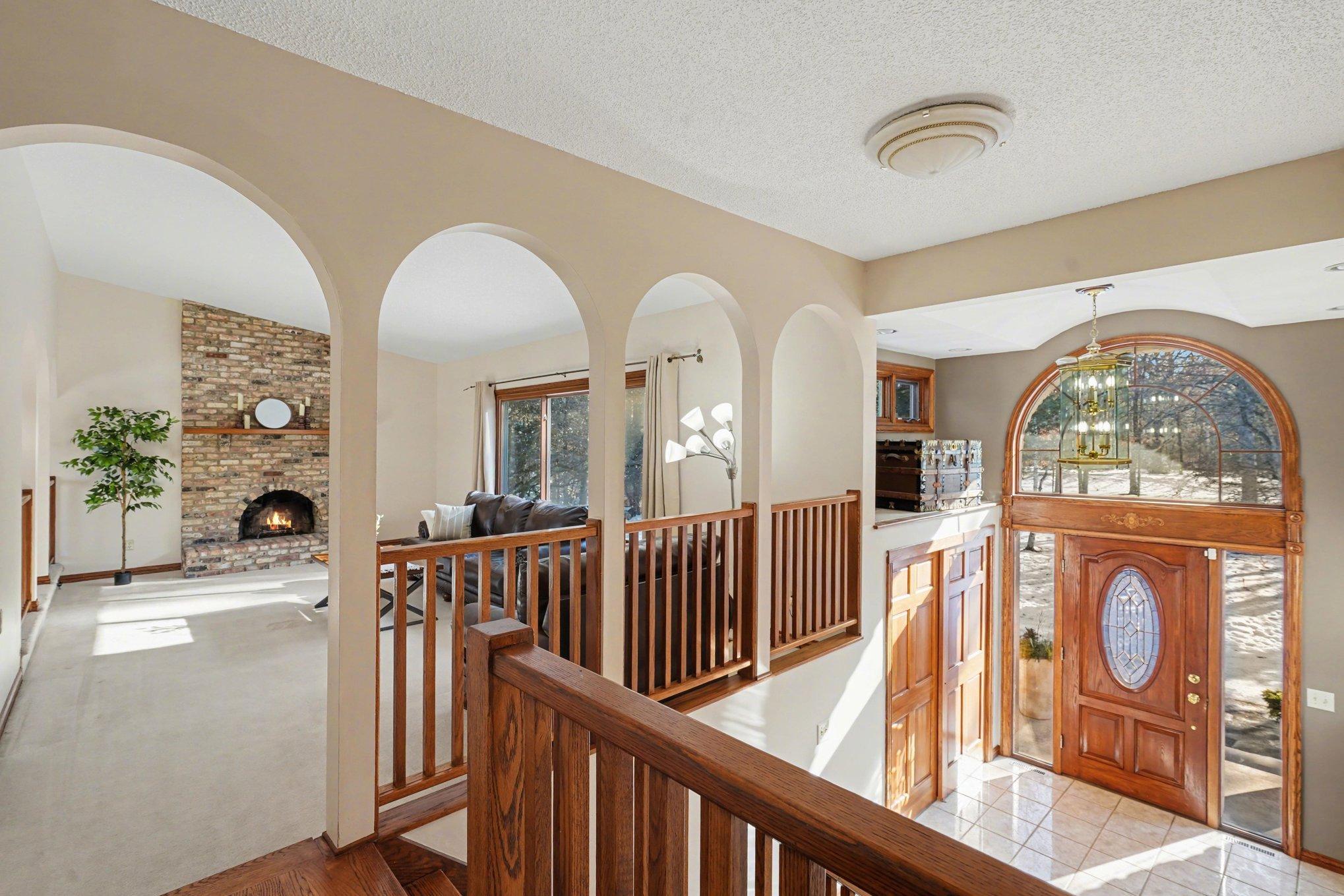 Thoughtfully designed w/solid-wood 6-panel doors, two laundry rooms, & extensive storage throughout. The upper level overlooks the grand foyer while showcasing beautiful hardwood floors & architectural arched doorways.