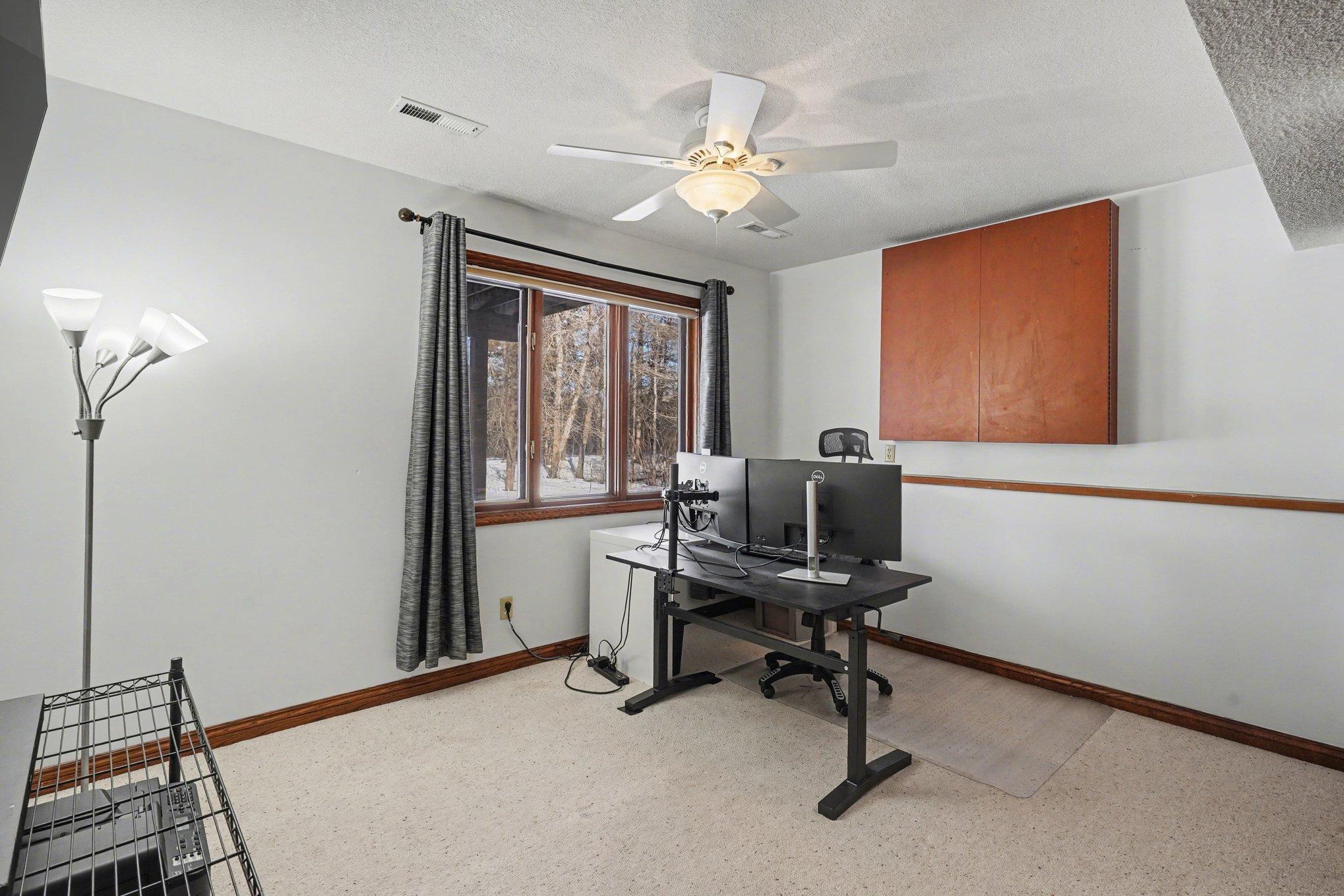 This spacious third bedroom offers dual closets and serene views of the backyard. A ceiling fan and large window keep the space bright—perfect for a home office or guest room!