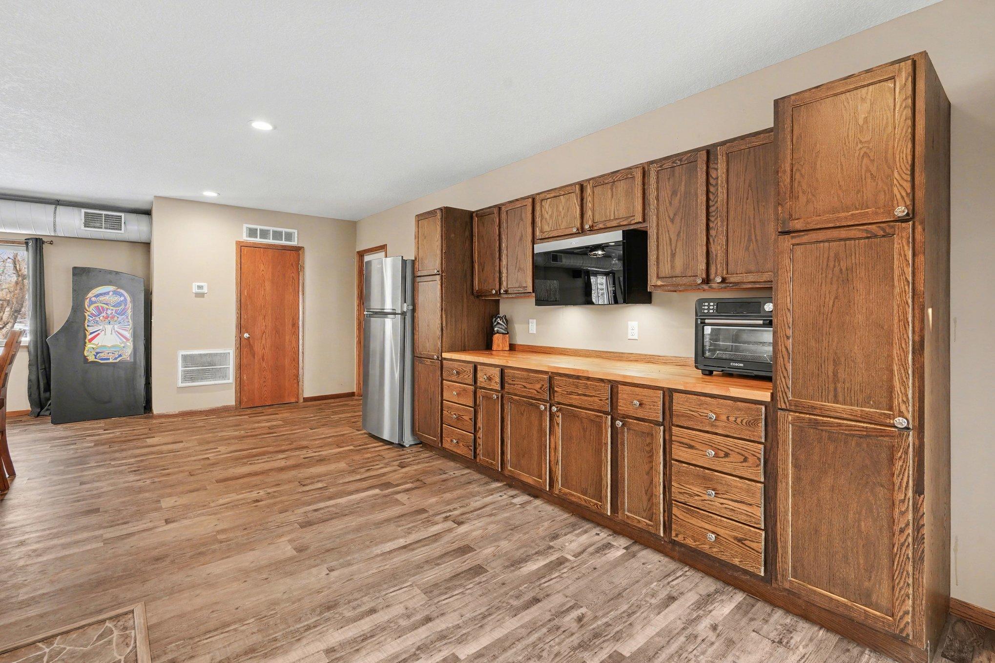 The built-in cabinets and buffet make for a perfect entertainment space. The refrigerator & microwave stay with the home for easy food & beverage storage. There is a large storage closet that also provides another entrance to the 4+ car garage.