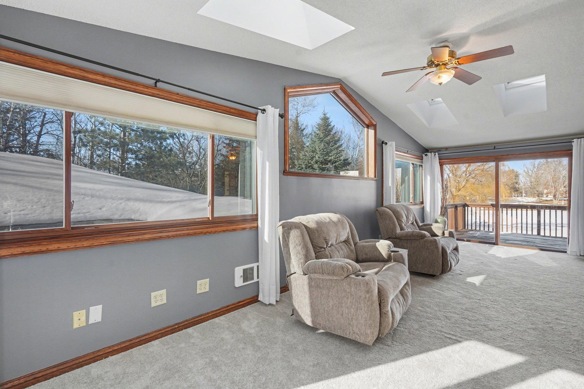 This view showcases the wall of windows, 4 skylights and sliding door to your private 9'x11' deck. A peaceful sanctuary to start your day or relax in the evening while enjoying the gorgeous, wooded views.