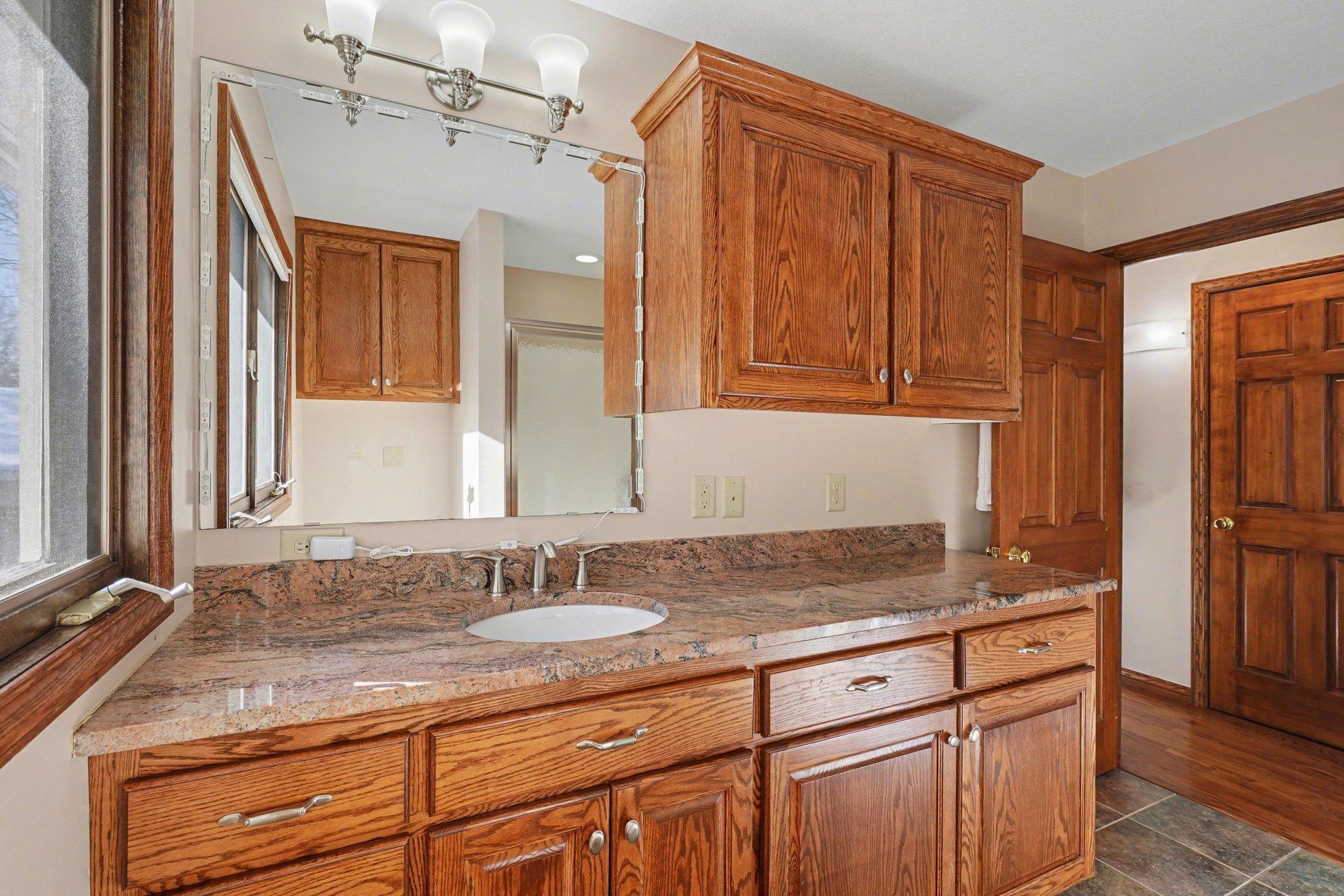 The upper-level laundry and 3/4 bath features a granite-topped comfort-height vanity and plenty of built-in storage for your bathroom or laundry needs. A thoughtfully designed space that makes daily chores a breeze!