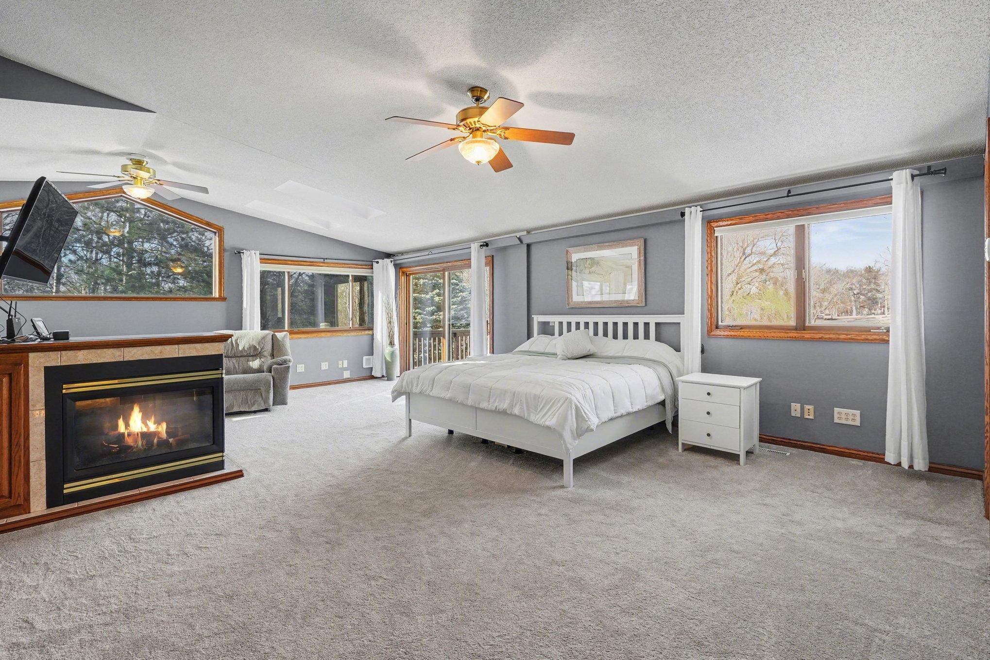 Prepare to be wowed! The primary bedroom incl. a vaulted ceiling, a cozy 3-sided gas fireplace, large walk-in closet & walls of windows. It features passthrough access to the full bathroom. This is your private escape!