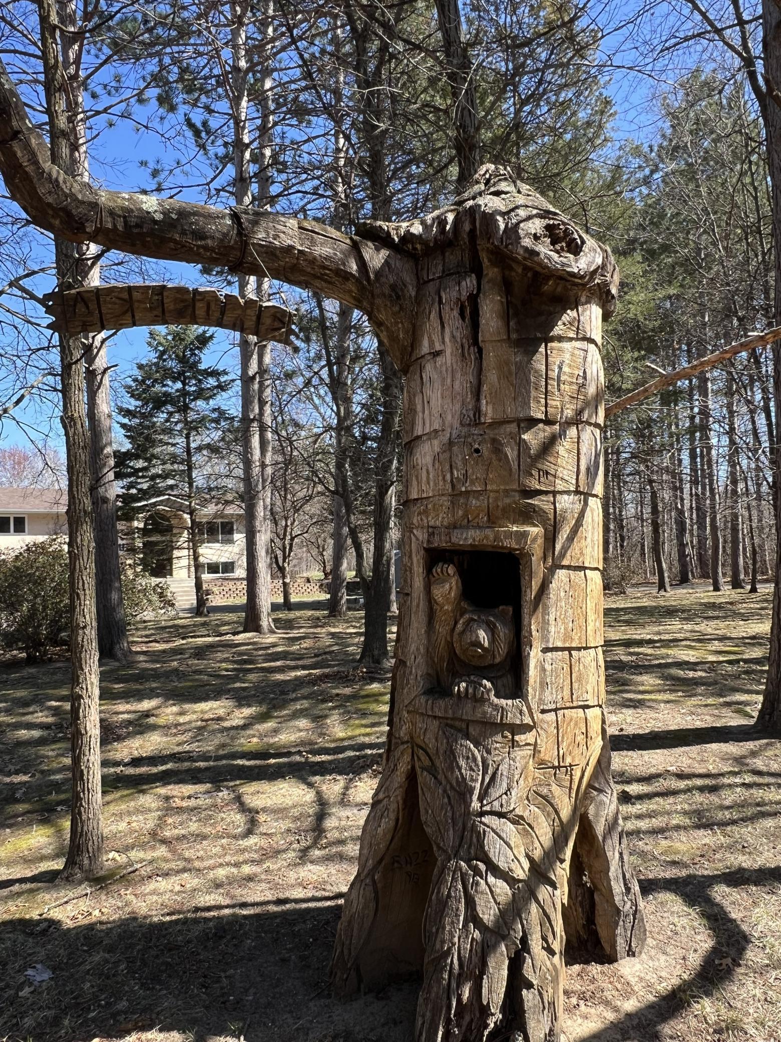 A charming carved tree bear greets you and your guests in the front yard, adding a touch of rustic character to this stunning property. The perfect woodland welcome!