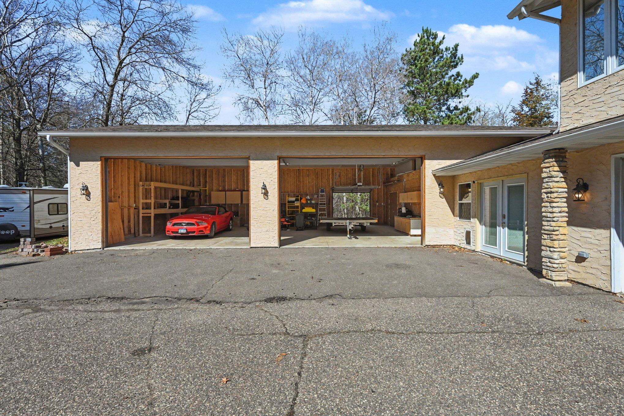 The ultimate sanctuary for your collection. This 4-car garage is a pro workshop with 16' doors, a pass-through door, and 200-amp service for EVs or welding. Plus a 30-amp RV hookup! Your toys finally have the home they deserve.
