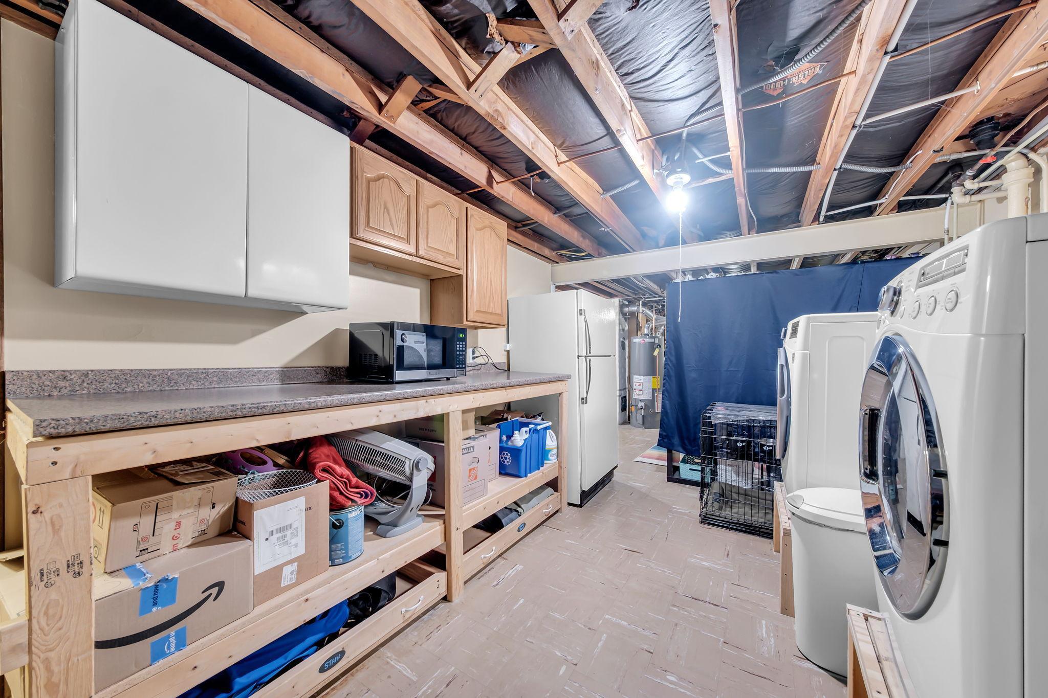 Basement workshop area with gas line for stove; existing stove in garage is available to stay.