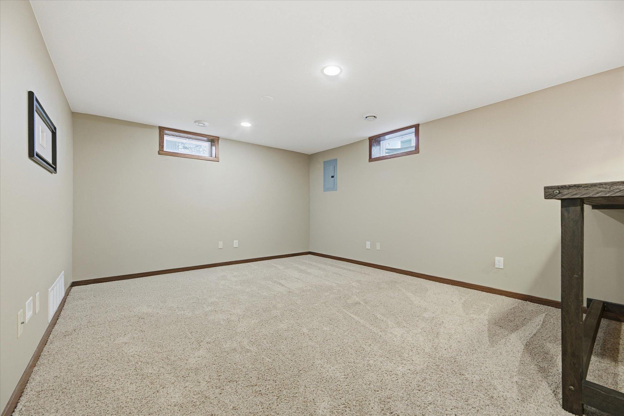 Large lower-level living room featuring plush carpet, recessed lighting, and a versatile layout perfect for an entertainment or recreation space.