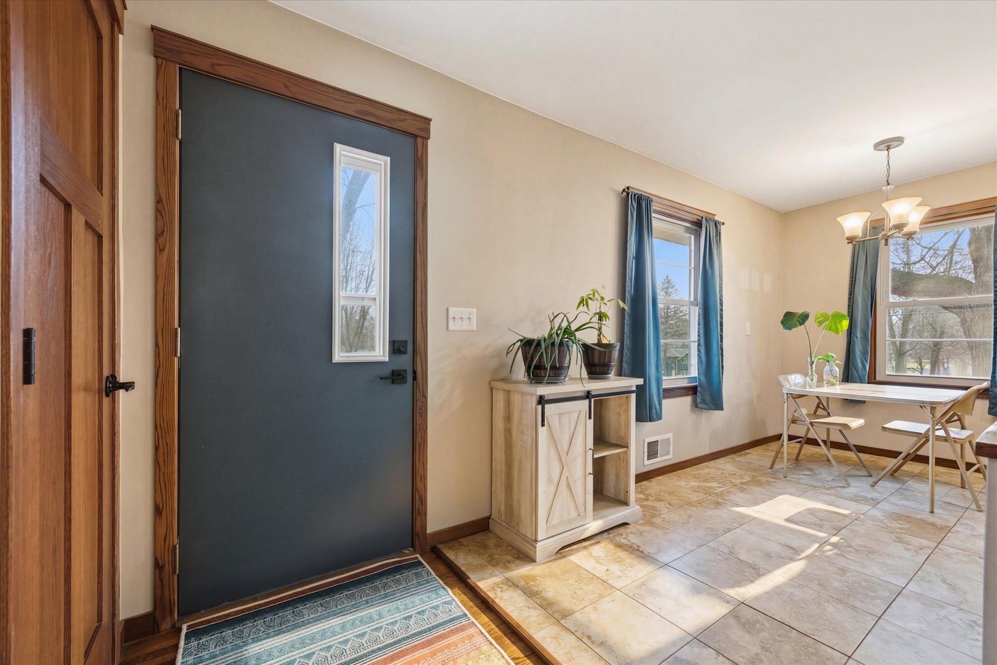 Step inside to a warm and inviting entryway with a modern front door and sun-filled.