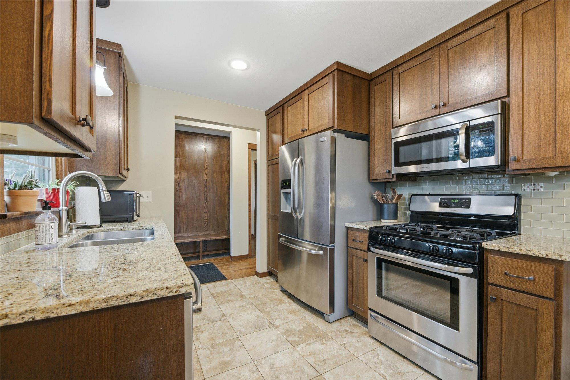Enjoy a beautifully updated kitchen with new cabinets, granite countertops, tile backsplash, and stainless steel appliances.
