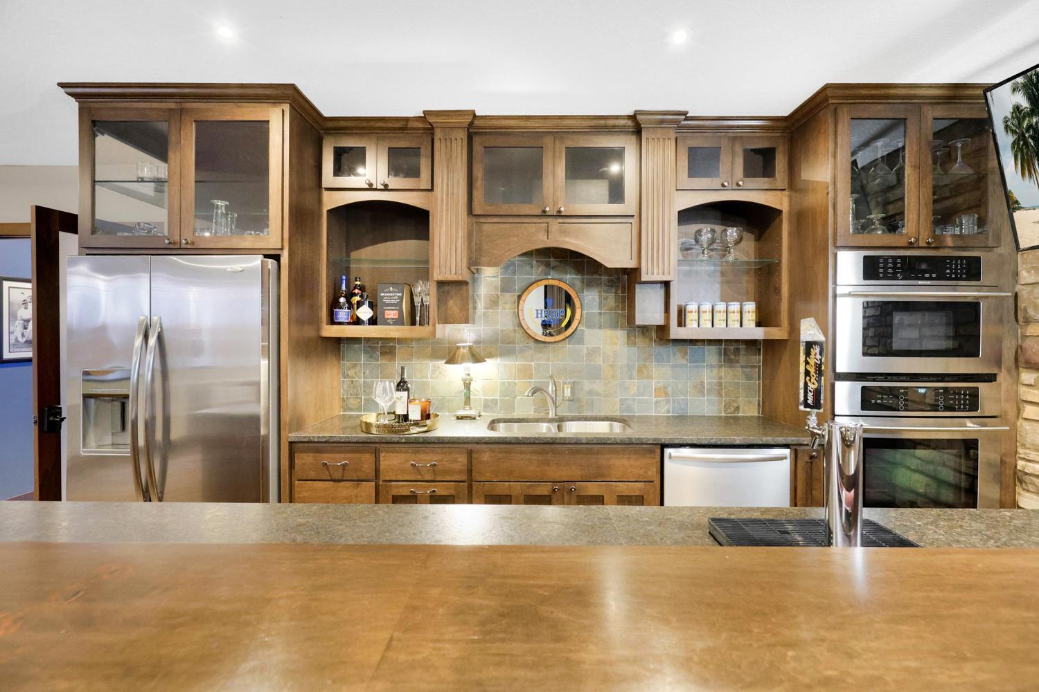 Lower level theater features a gorgeous custom built bar complete with fridge, oven, microwave, dishwasher and bar tap.