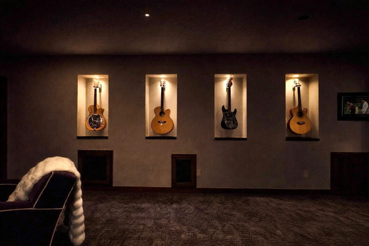 Custom guitar display adds a unique touch to the theater room and features a hidden built in amplifier.