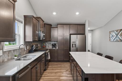The heart of the home features quartz countertops, stainless appliances, abundant cabinetry, and a massive center island.