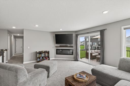 Cozy up by the fireplace while enjoying views of the backyard and neighborhood green space.