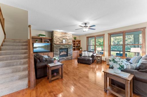 The living room features a beautiful stone fireplace and large windows overlooking the golf course.