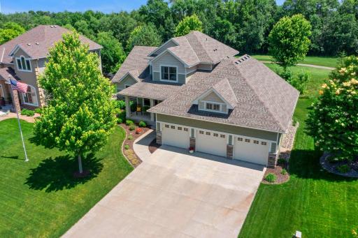 This home features a wide concrete driveway and an expansive three-car garage.