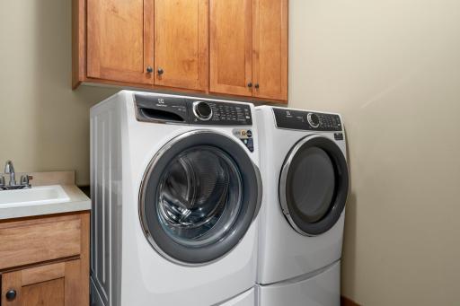 The laundry room includes gorgeous wood cabinets.