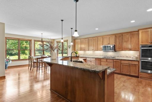 The kitchen features a large island, granite countertops, stainless steel appliances, custom cabinets and a large pantry.