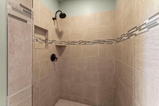 The primary bathroom features a gorgeous tiled shower.
