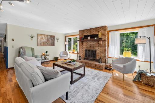 Wood burning fireplace surrounded by bay windows.