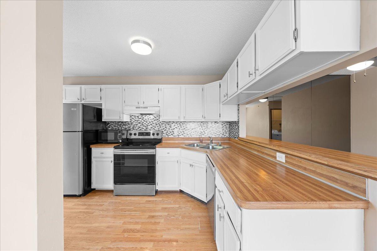 White cabinetry and S.S. appliances makes the kitchen shine.