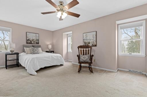Spacious primary bedroom with soft natural light and room to unwind