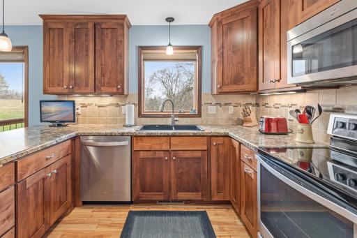Updated kitchen with rich wood cabinetry, tile backsplash, and stainless appliances