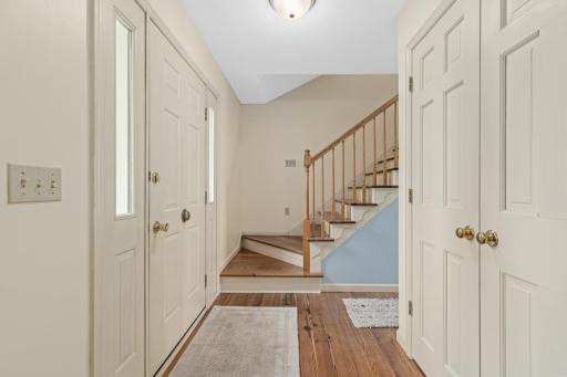 Bright foyer entry with warm wood floors, closet storage, and a welcoming first impression