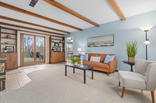 Family room with fireplace, built-ins, and a beamed ceiling