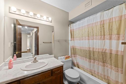 Full-size bathroom featuring under-sink storage and a dedicated linen closet conveniently located in the hall.