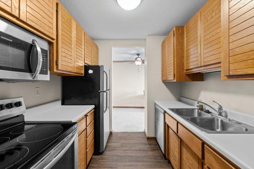 Modern stainless steel appliances, including a dishwasher and range, add both convenience and style to the kitchen.