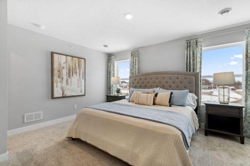 An oasis of its own, the primary suite offers the perfect escape. There's immediate access to a private bathroom that features dual sinks and a large shower. Photo is of model home. Colors and options may vary. Ask Sales Agent for details.