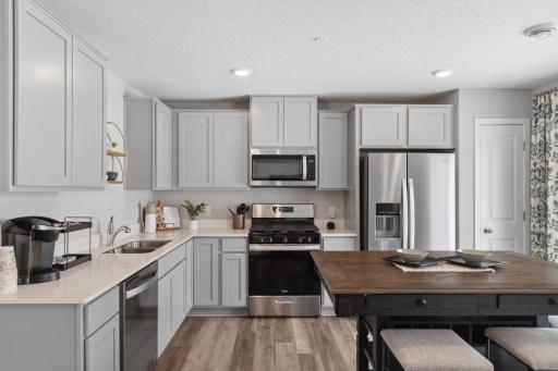 Stainless steel appliances and quartz countertops. Photo is of model home. Colors and options may vary. Ask Sales Agent for details.