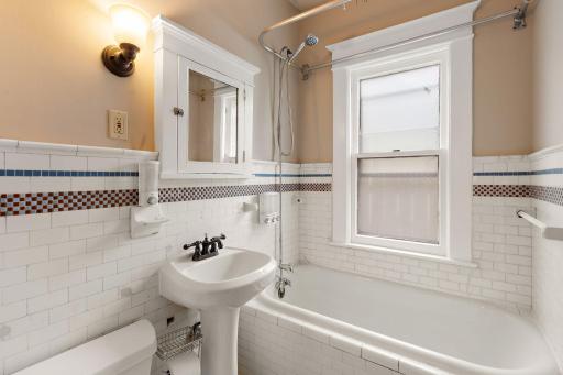 The main floor full bath has original tile walls & floors.