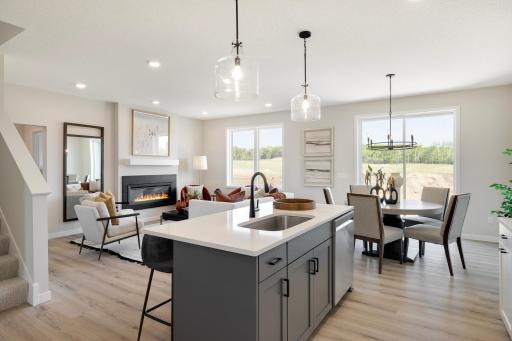 This home features a stunning open-concept design that seamlessly connects the family room, kitchen, and dining area, creating an ideal space for both daily living and entertaining. Photos are from previously built home; options and features may vary