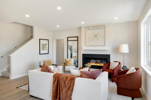 The heart of this home is the cozy family room, designed for both comfort and relaxation. Featuring a modern electric fireplace, it provides a warm and inviting atmosphere. Photos are from previously built home; options and features may vary.