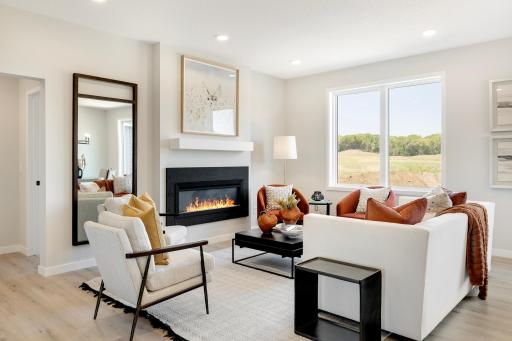 The heart of this home is the cozy family room, designed for both comfort and relaxation. Featuring a modern electric fireplace, it provides a warm and inviting atmosphere. Photos are from previously built home; options and features may vary.