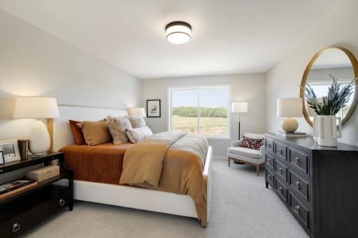 The primary suite is a tranquil retreat, offering both comfort & privacy. Spacious & elegantly designed, it provides a serene escape from the rest of the home. Photos are from previously built home; options and features may vary.