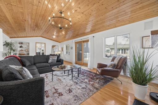 Vaulted ceiling living room with door to deck