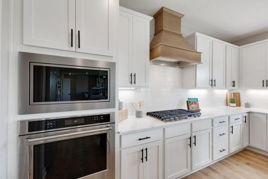 Upgraded Gourmet Kitchen includes: KitchenAid wall oven and microwave, gas cooktop, dishwasher, pull out trash, and a wood hood. Color shown will be color package in home for sale.