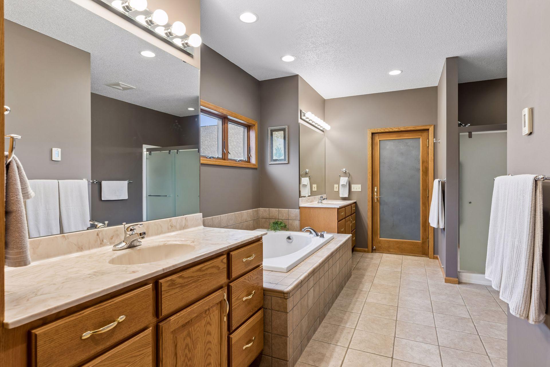 Primary suite features tub and shower as well as dual vanities