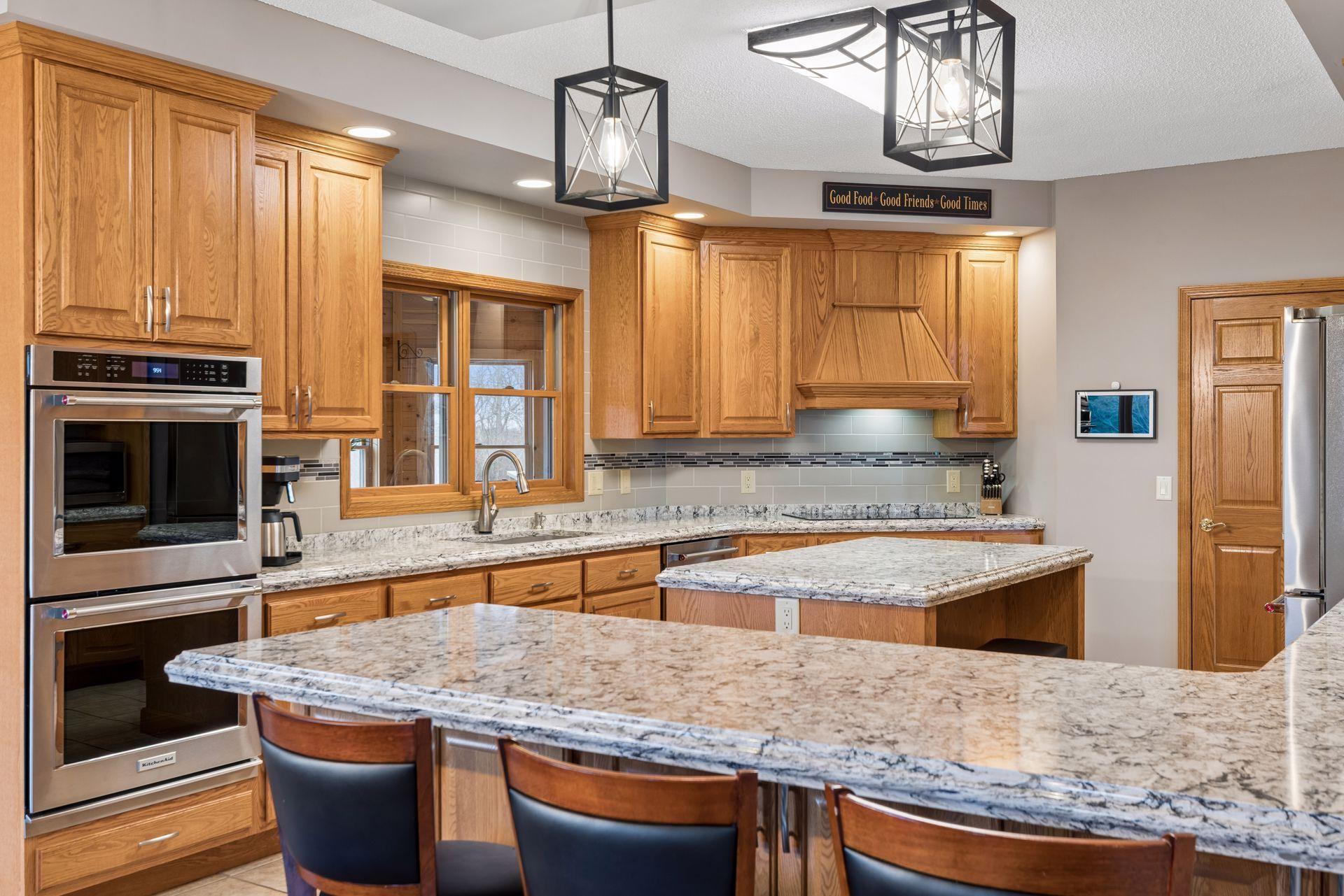 Stunning kitchen features Cambria counters with seating at peninsula and center island