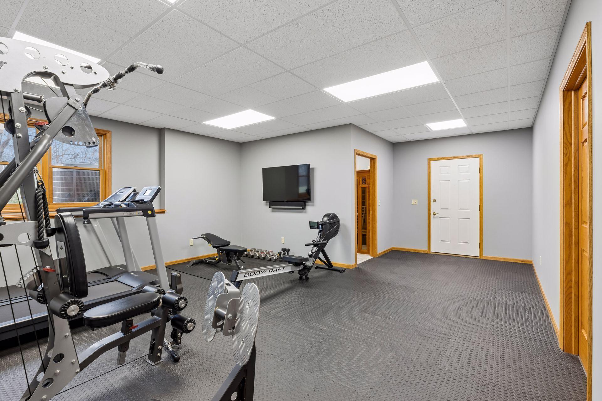 Spacious gym room in lower-level which could act as a 5th bedroom, with walkout to the garage