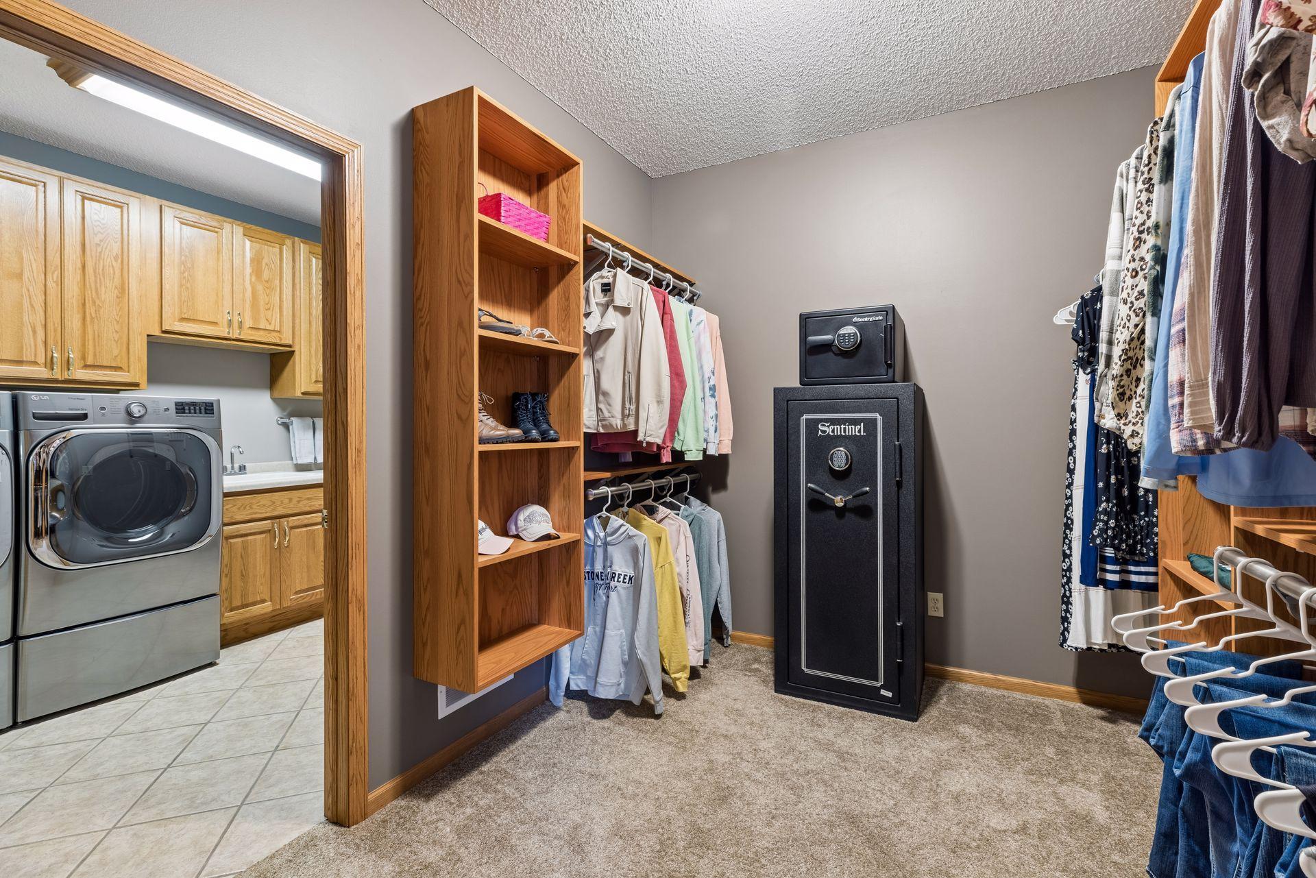 Large walk-in closet in primary suite with direct access to laundry room