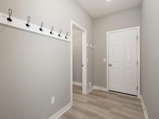 Generous mudroom with hooks and larger closet to the left. Access to the 3 car garage is straight ahead.