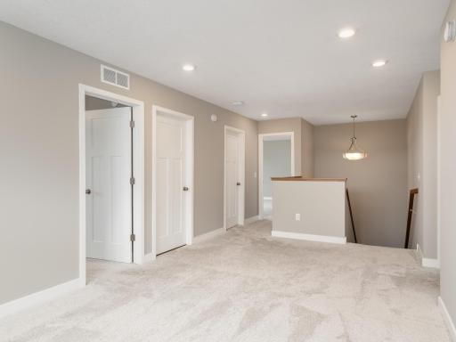 Looking back towards the steps and the lower level, the laundry room is to the left and the ownerâs suite is through the open doorway.