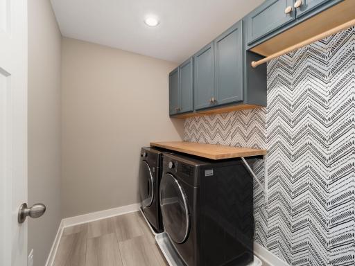 Well equipped laundry room with front loading washer and dryer, overhead cabinets and space to hang clothes when they come out of the dryer. Great location between all of the bedrooms.