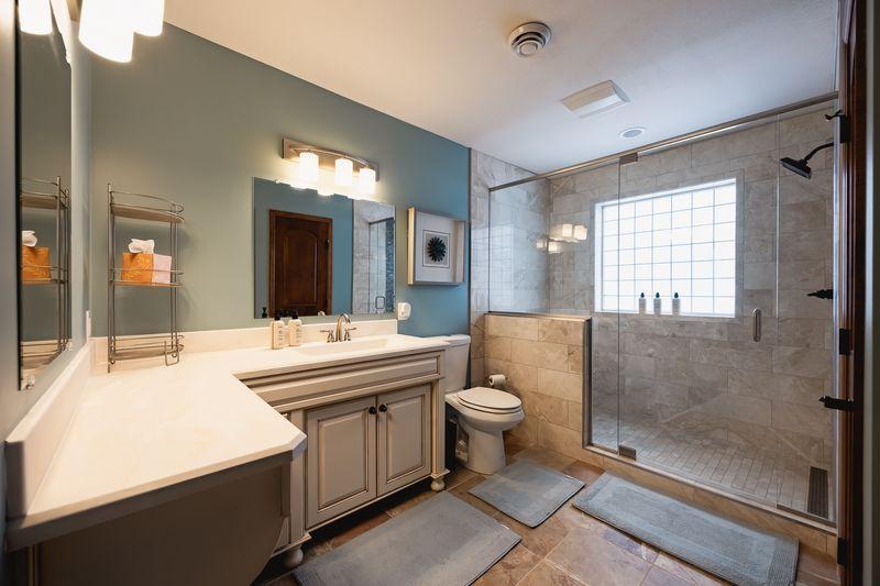 Remodeled (2025) upper level bath with tiled walk in shower.